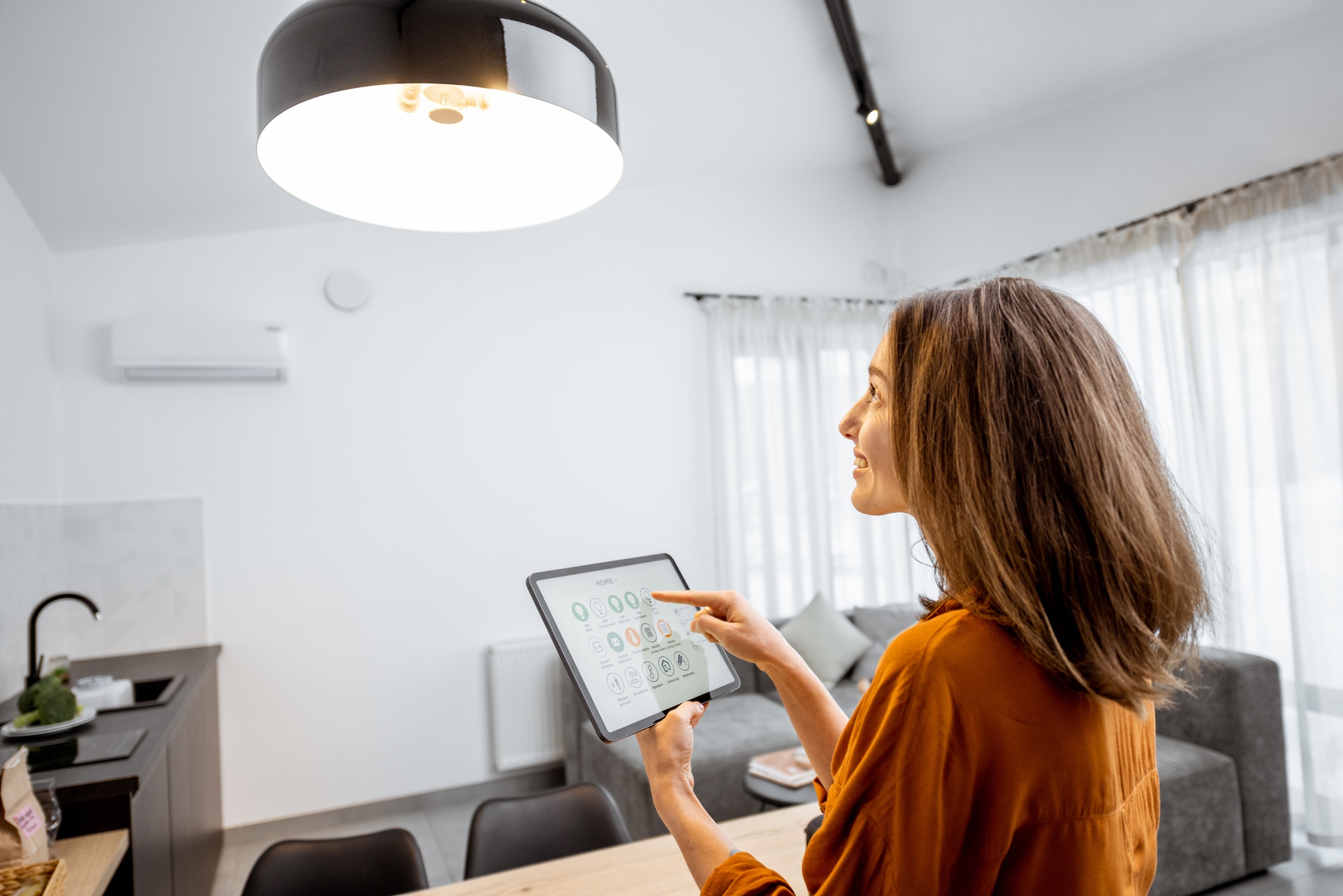 Femme qui allume sa lumière avec sa tablette