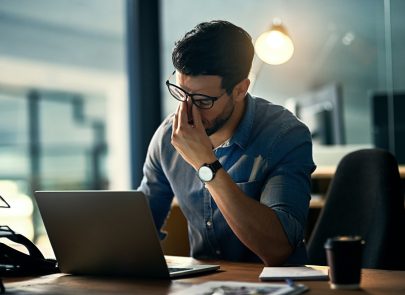 Homme fatigué derrière son ordinateur portable
