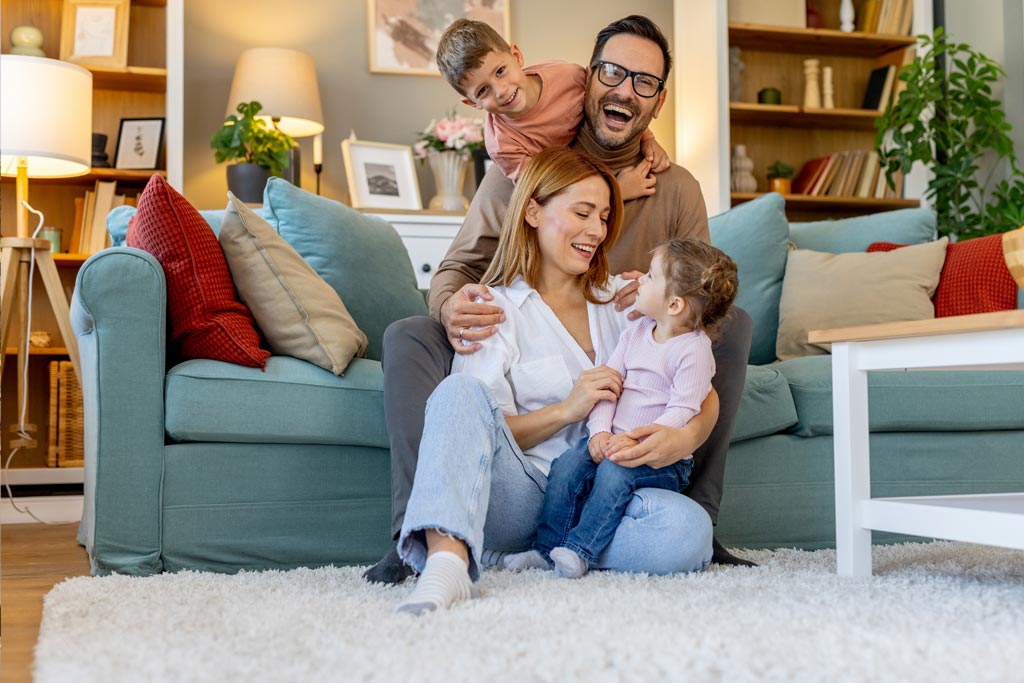 image d'une famille qui rigole dans le salon