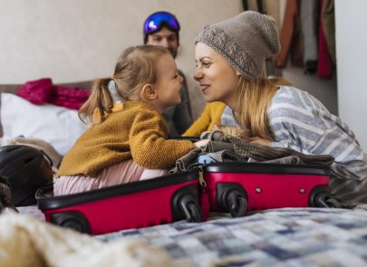 Plan d'une famille heureuse faisant ses valises pour des vacances d'hiver.