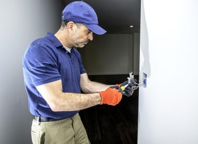 image d'un professionnel intervenant sur un interrupteur mural de lumière