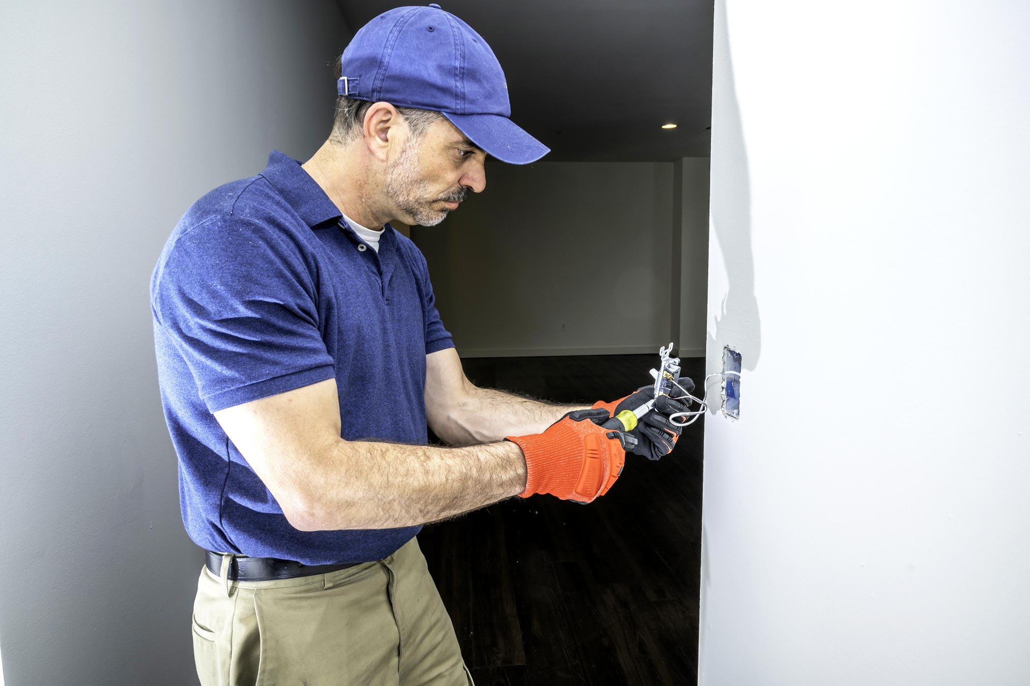 image d'un professionnel intervenant sur un interrupteur mural de lumière