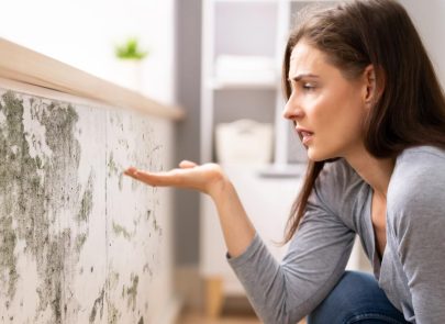 une femme devant un mur de moisissures