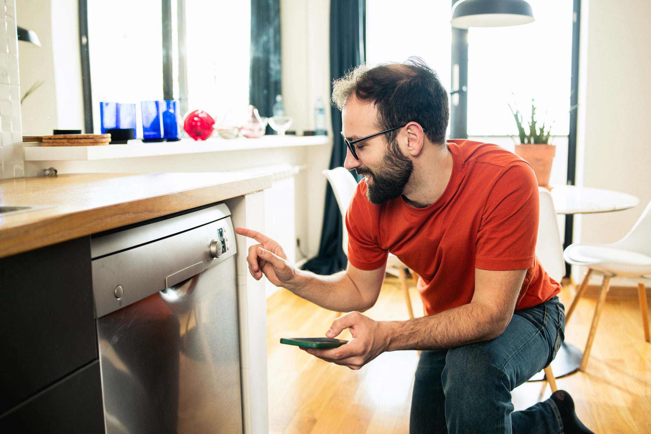image d'un homme devant un lave vaisselle pour régler une plage horaire de programme