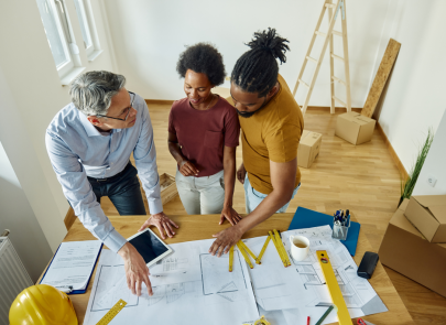 groupe de personne discutant sur un plan de travaux de construction