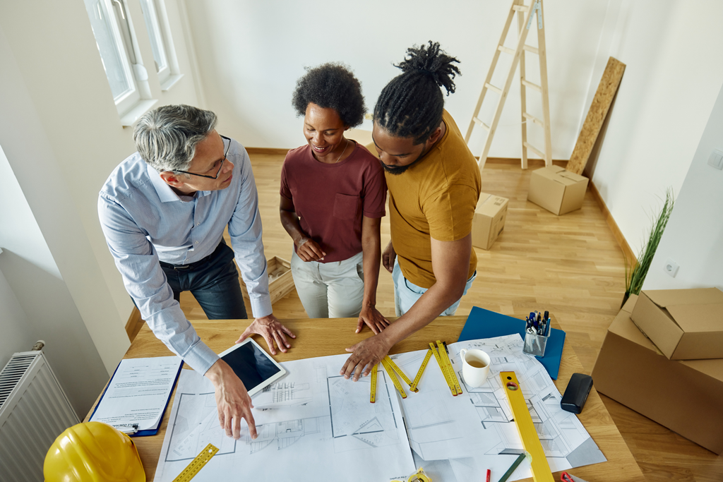 groupe de personne discutant sur un plan de travaux de construction