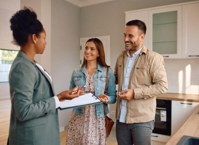 une femme devant un couple simulant une vente immobilière dans une cuisine