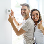 image d un couple devant un mur avec un boitier thermostatique