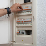 image d'une main intervenant sur un tableau électrique