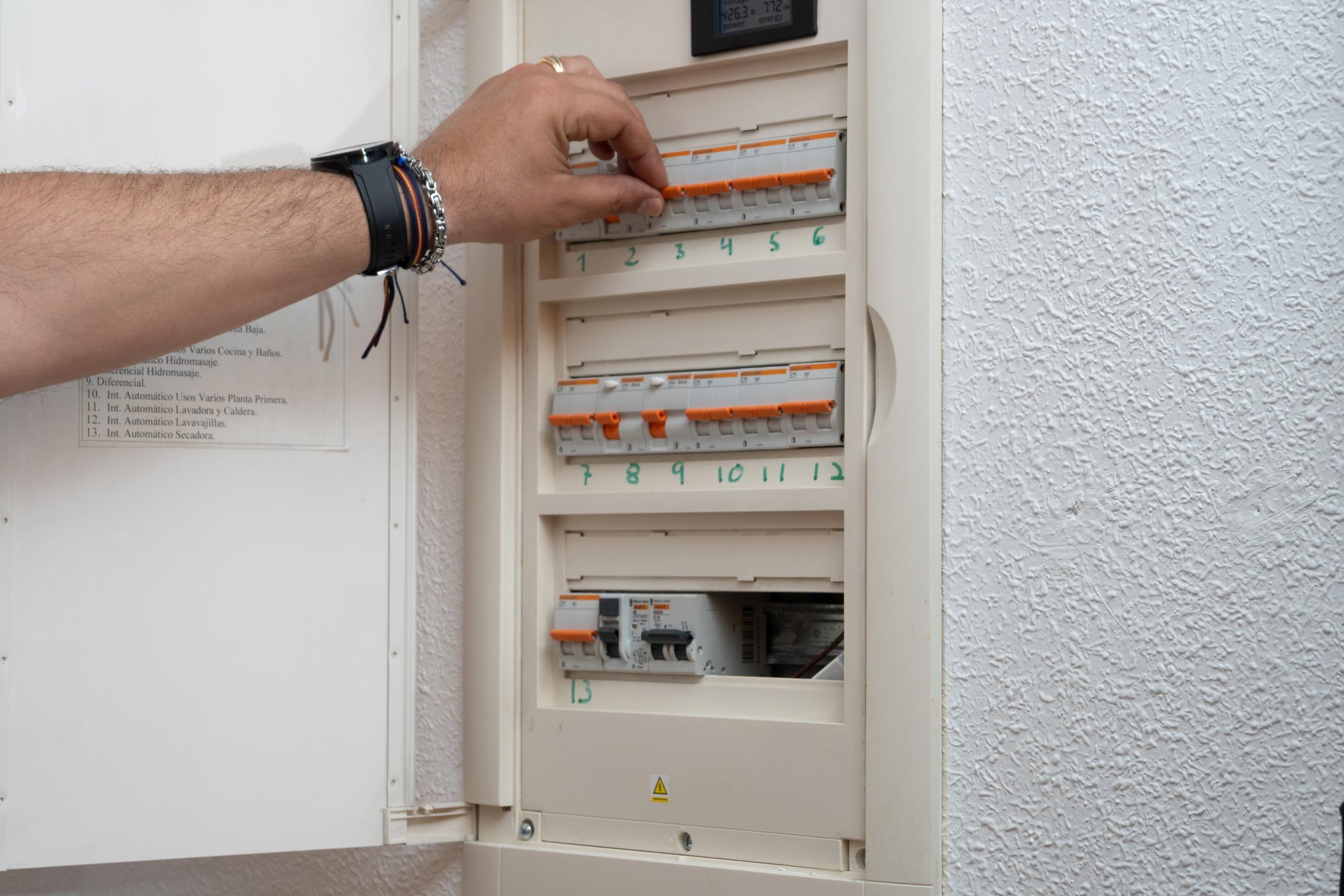 image d'une main intervenant sur un tableau électrique
