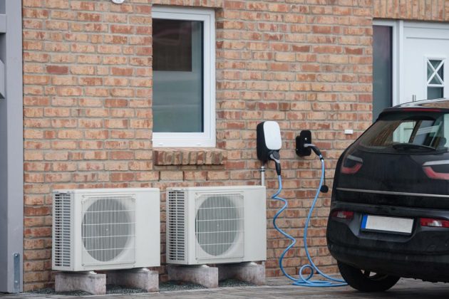 image d'une voiture electrique qui charge à coté d'un mur